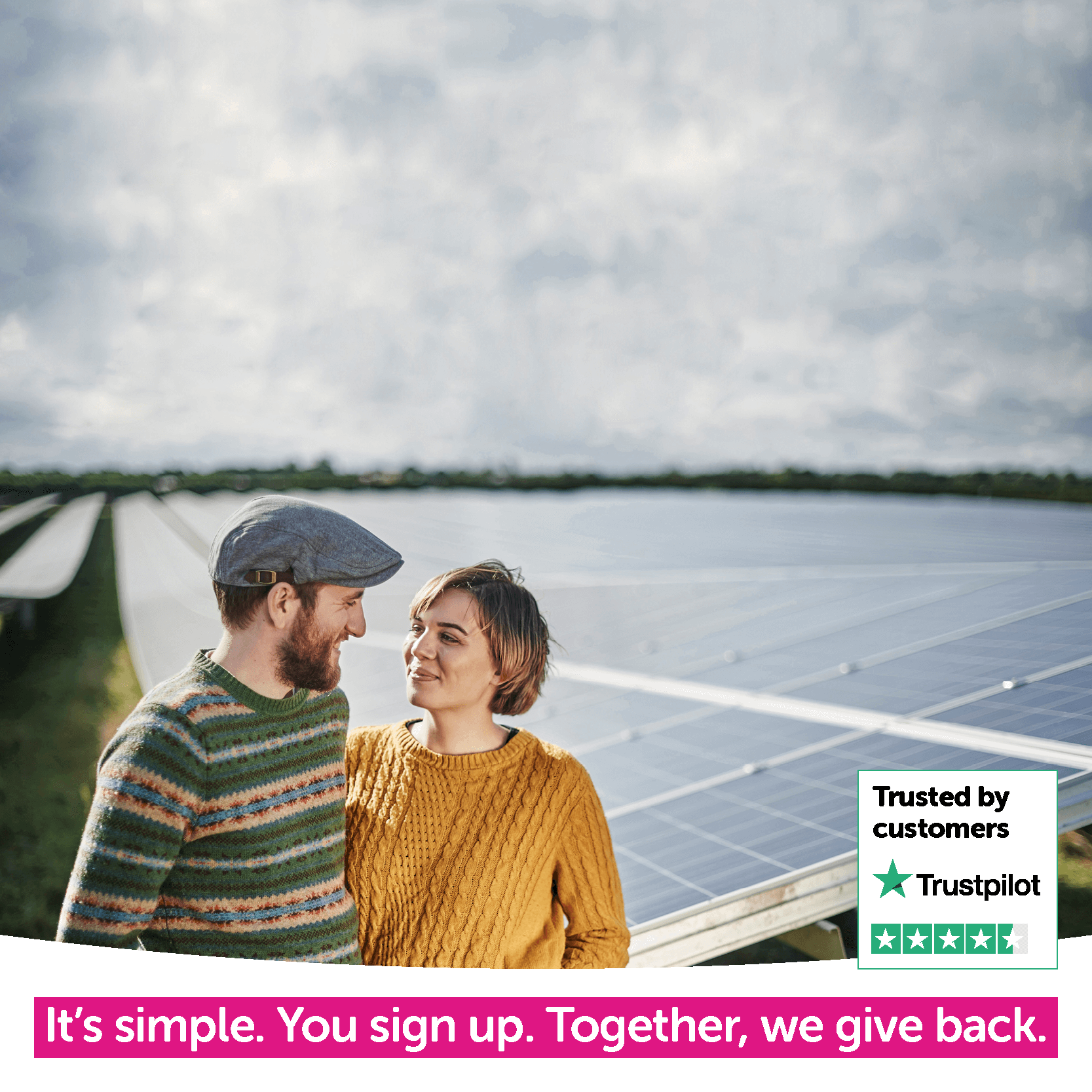 couple stood next to solar panels looking at each other