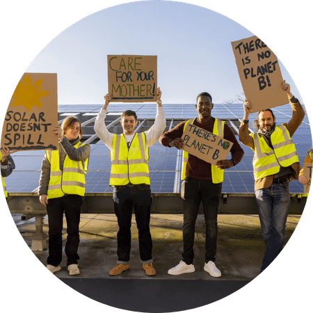 campaigners holding signs next to solar panels