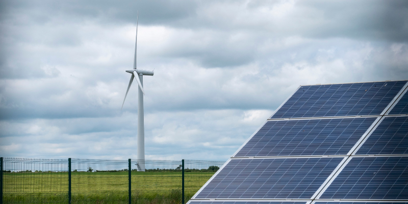 solar panel and wind turbine in a field