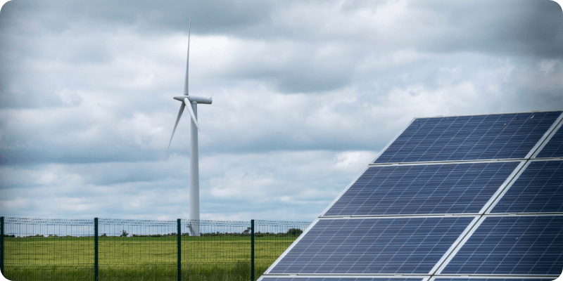 solar panel and wind turbine in a field