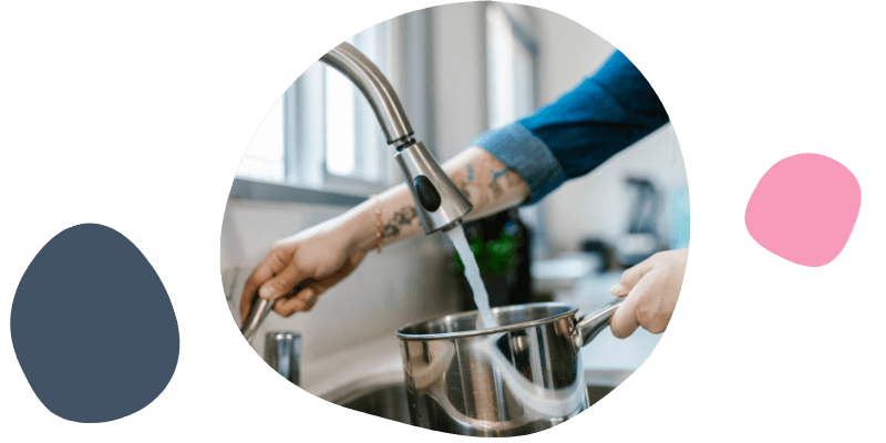 person filling up their saucepan with hot water