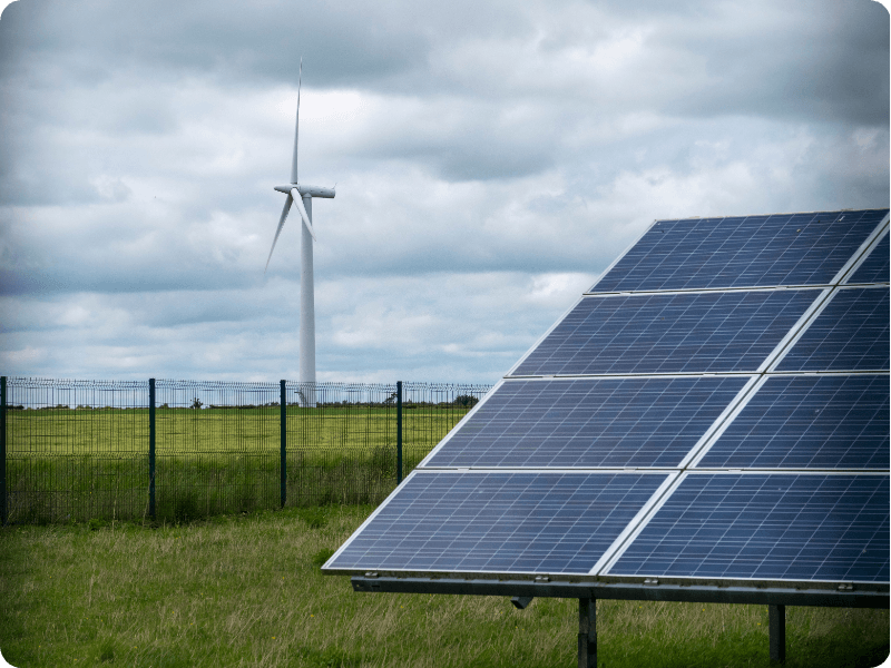 solar panel with a wind turbine in the background