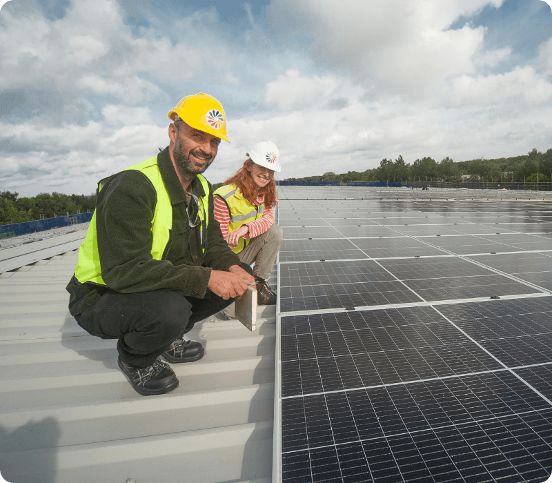 workers stood on roof with solar panels