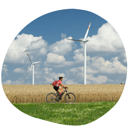 person riding their bike with wind turbines in the background