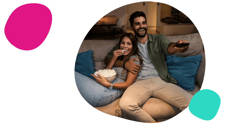 young couple sat watching the TV together