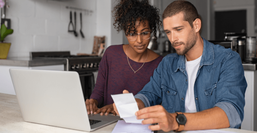 couple checking their bills using a laptop