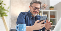 Man using his mobile whilst enjoying a coffee