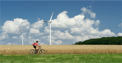 person riding their bike near wind turbines